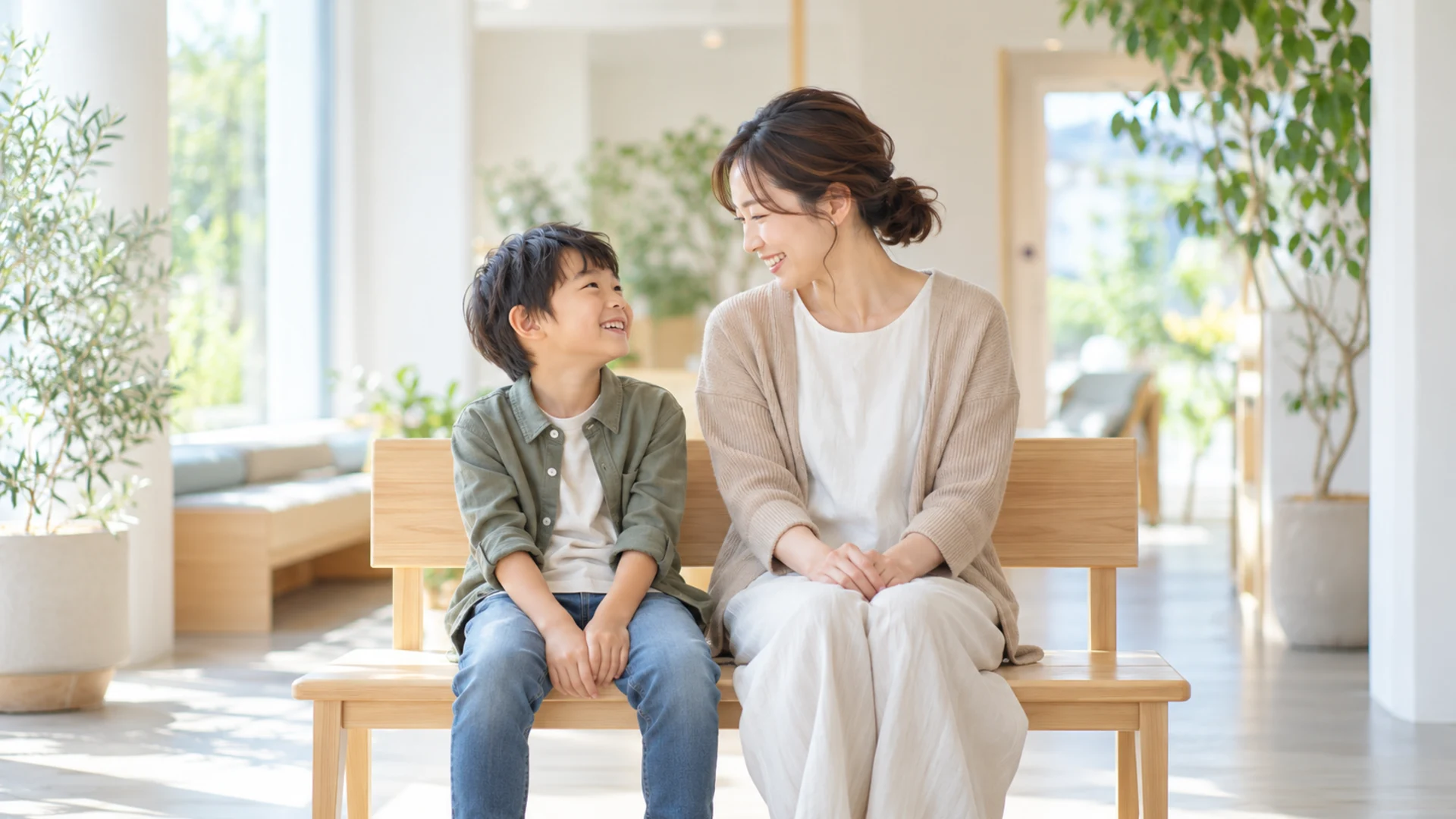 並んで座り、笑顔で話す母親と小学生の男の子